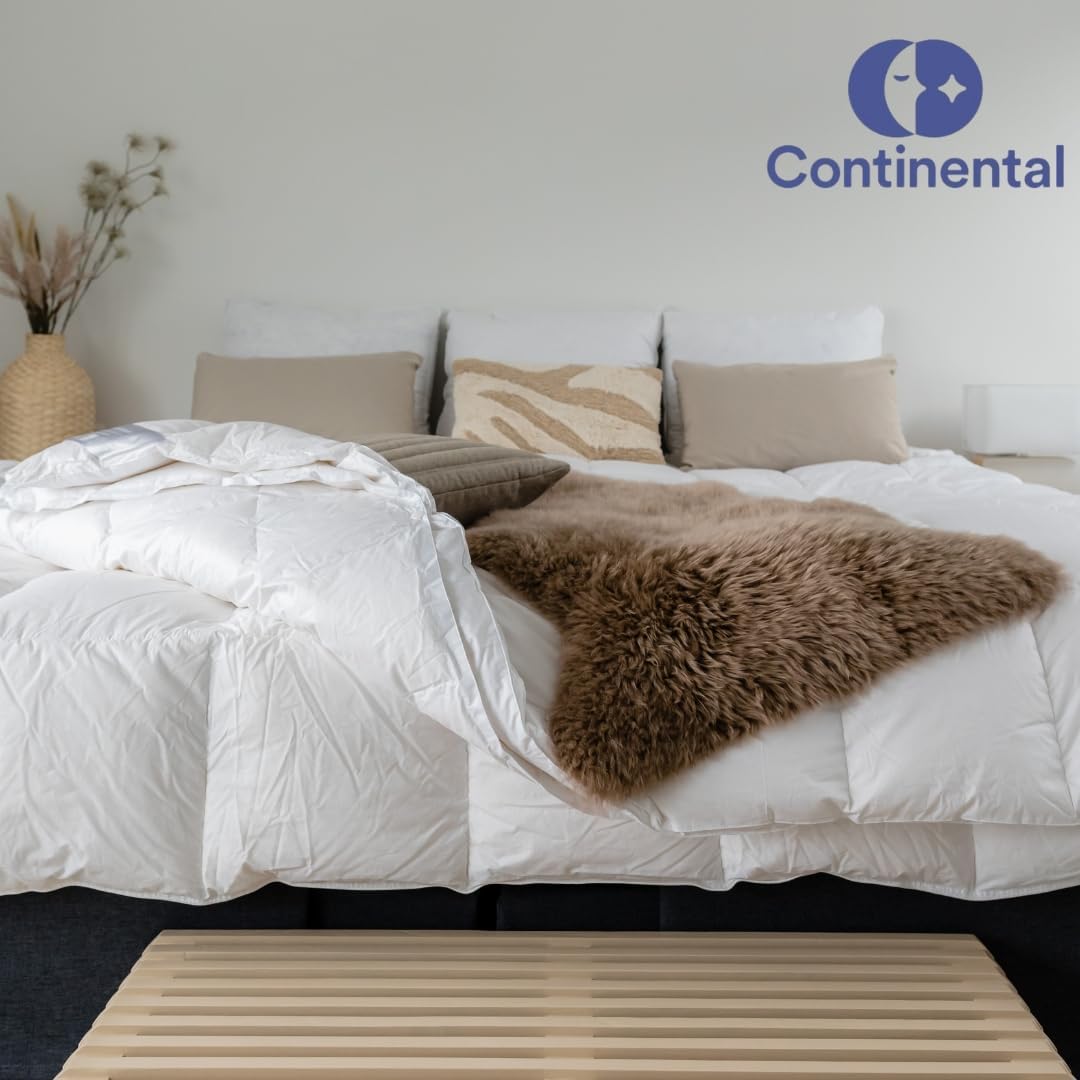 Continental Bedding luxury comforter styled on a modern bed with neutral pillows, textured accents, and a cozy faux fur throw, showcasing soft bedding in a minimalist bedroom setup.