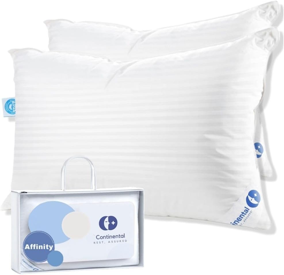 Two Continental Bedding Affinity down alternative pillows in white, featuring a subtle striped design, displayed prominently with one pillow slightly overlapping the other. Below them is their stylish packaging, a silver box with the 'Affinity' and 'Continental Bedding' branding visible, designed for attractive and practical presentation