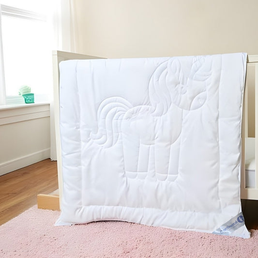 White toddler comforter with unicorn quilting draped over crib rail, 33x42 inches, cotton shell and polyester fill.

