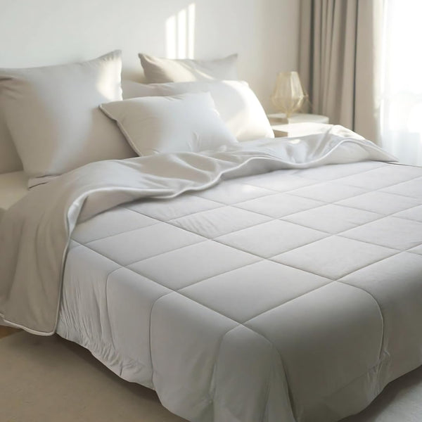 A modern, minimalist bedroom with a bamboo bedding set in a neutral color, featuring a plush comforter and matching pillowcases.