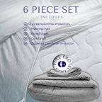 A six-piece bamboo bedding set neatly stacked, including a comforter, fitted sheet, mattress pad, zippered pillow protectors, and a zippered comforter protector.

