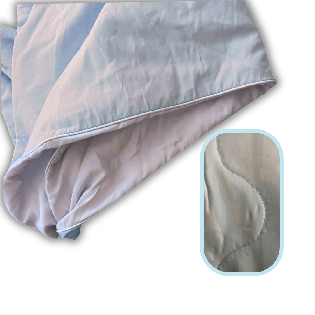 Light blue bamboo comforter shown with wave-style stitch detailing and soft, breathable fabric highlighted in a close-up inset.

