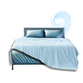 Light blue cooling comforter and pillow set on a modern bed with a swirl of cool air and snowflake graphics suggesting breathable, temperature-regulating fabric.