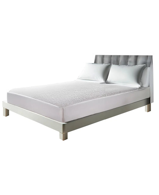 Modern bedroom featuring a minimalistic bed with a sleek gray upholstered headboard and a white mattress protected by a textured waterproof mattress protector, set on a simple metal frame. The neutral color palette provides a calm and clean sleeping environment