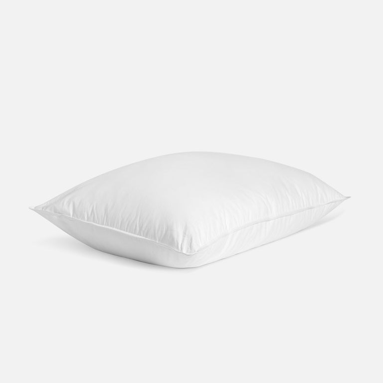 Soft, ergonomically designed toddler pillow with a fluffy shape and smooth white cotton cover, shown on a clean white background.

